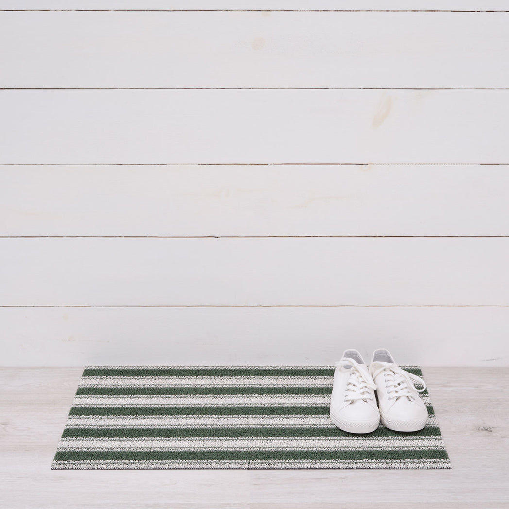 Chilewich striped woven mat with textured terrastrand yarn surface, featuring modern linear design and durable finish.