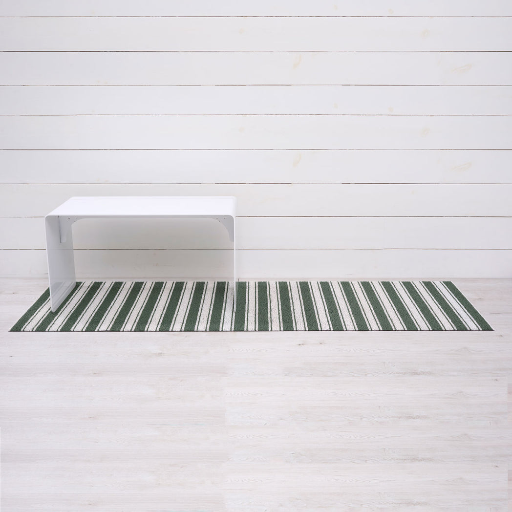 Chilewich striped woven mat with textured terrastrand yarn surface, featuring modern linear design and durable finish.