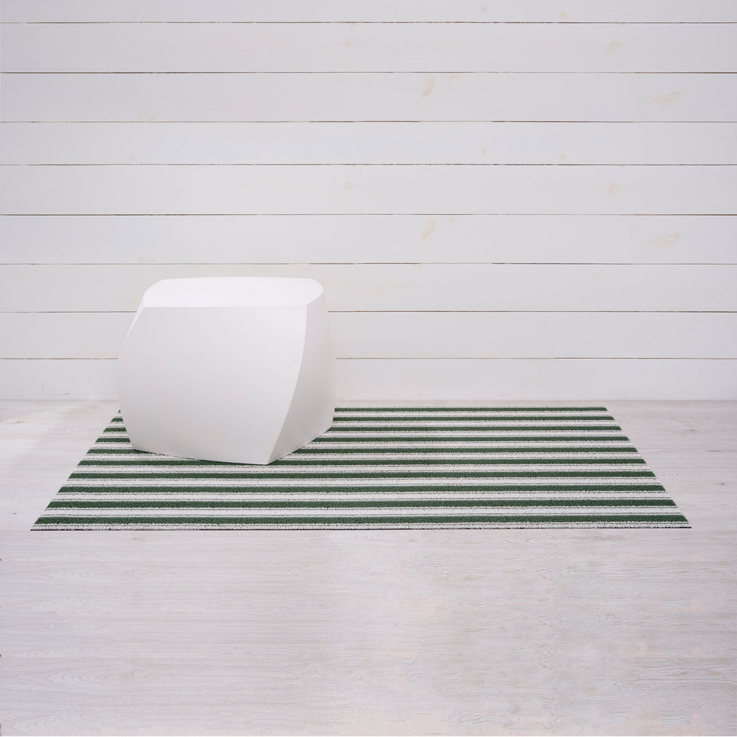Chilewich striped woven mat with textured terrastrand yarn surface, featuring modern linear design and durable finish.
