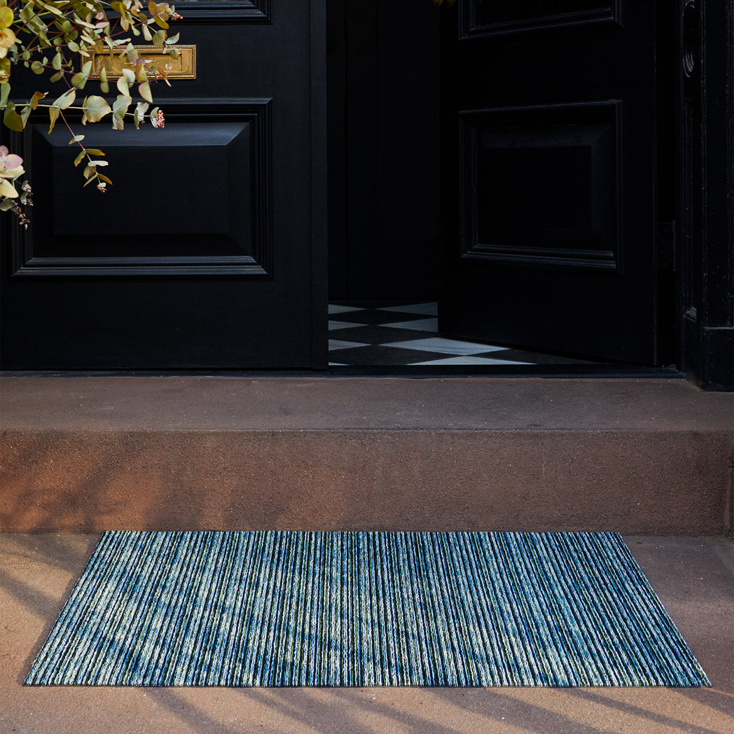 Chilewich striped woven mat with textured terrastrand yarn surface, featuring modern linear design and durable finish.