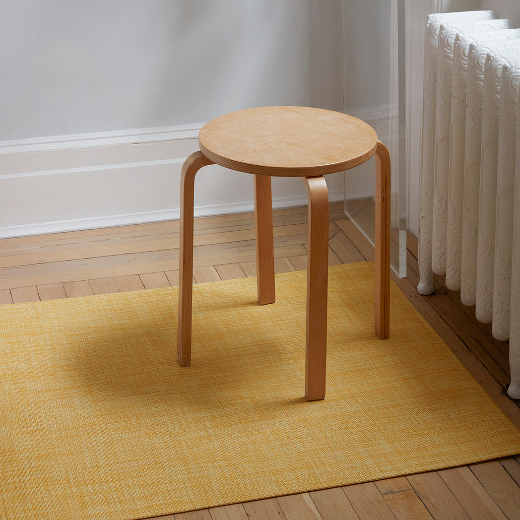 Chilewich Basketweave floor mat in Ochre, showcasing woven terrastrand yarn texture and modern design aesthetic.