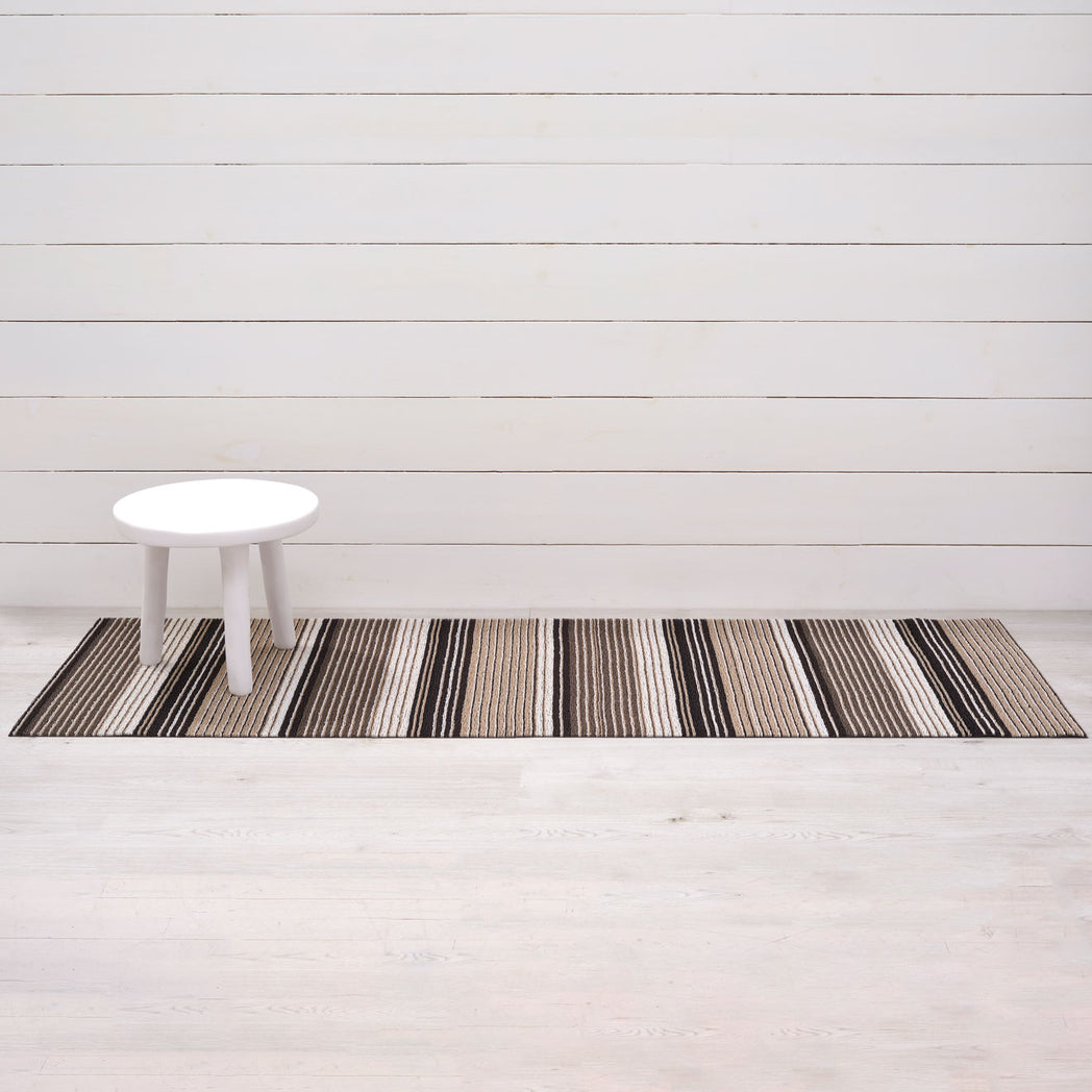Chilewich striped woven mat with textured terrastrand yarn surface, featuring modern linear design and durable finish.
