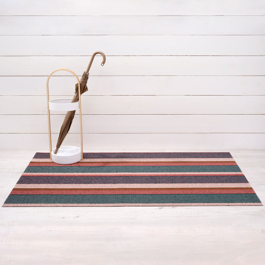 Chilewich striped woven mat with textured terrastrand yarn surface, featuring modern linear design and durable finish.