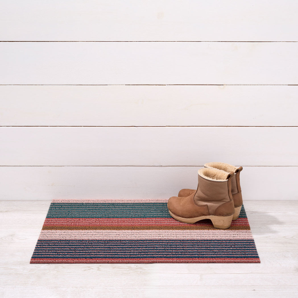 Chilewich striped woven mat with textured terrastrand yarn surface, featuring modern linear design and durable finish.