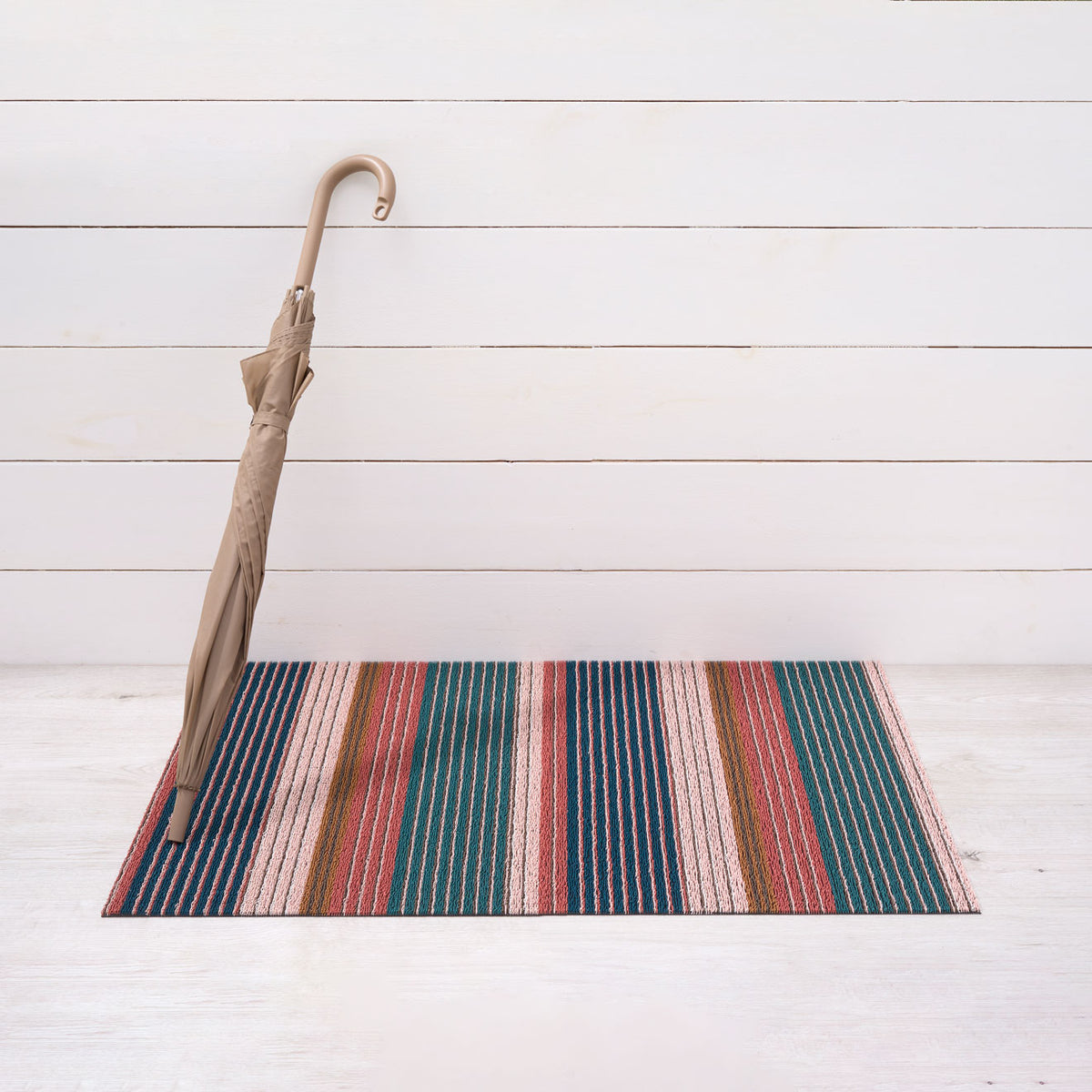 Chilewich striped woven mat with textured terrastrand yarn surface, featuring modern linear design and durable finish.