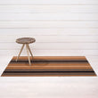 Chilewich striped woven mat with textured terrastrand yarn surface, featuring modern linear design and durable finish.