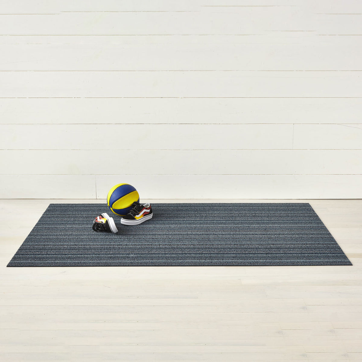 Chilewich striped woven mat with textured terrastrand yarn surface, featuring modern linear design and durable finish.