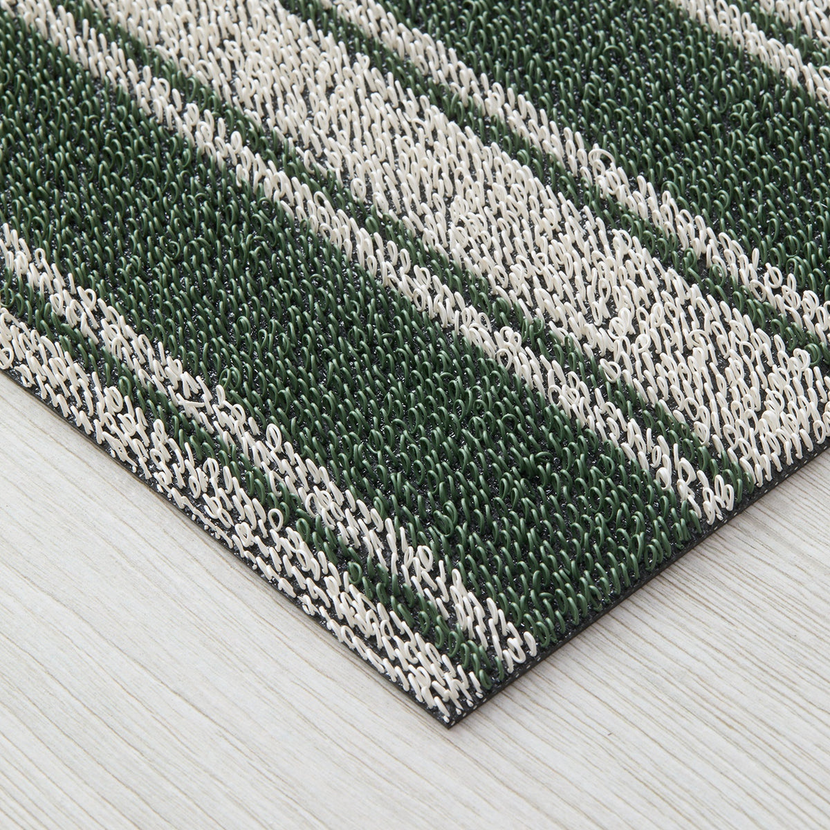Chilewich striped woven mat with textured terrastrand yarn surface, featuring modern linear design and durable finish.