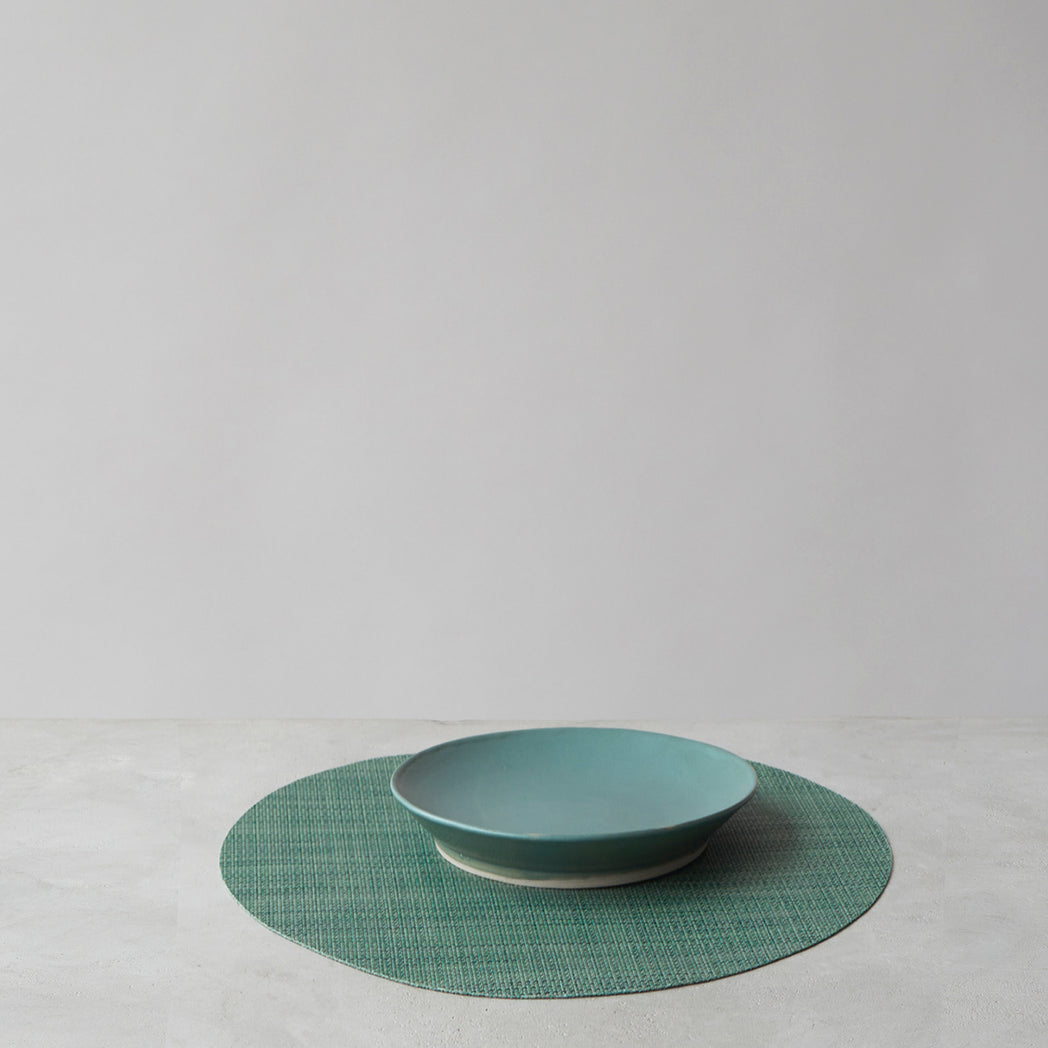Chilewich Basketweave floor mat in ivy, showcasing woven terrastrand yarn texture and modern design aesthetic.