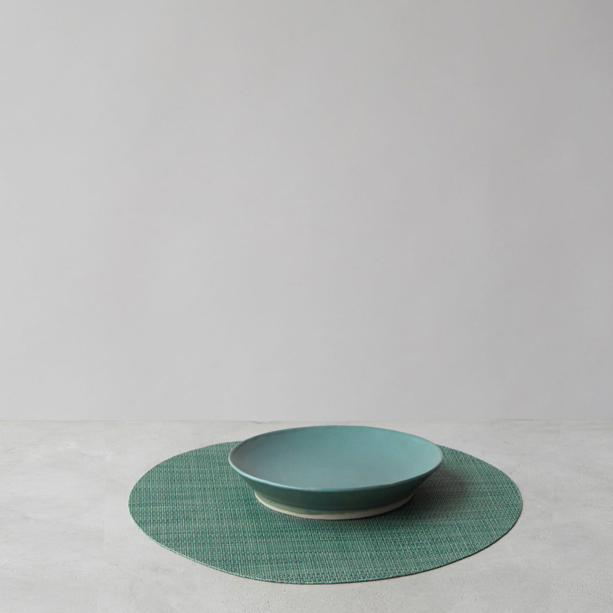 Chilewich Basketweave floor mat in ivy, showcasing woven terrastrand yarn texture and modern design aesthetic.