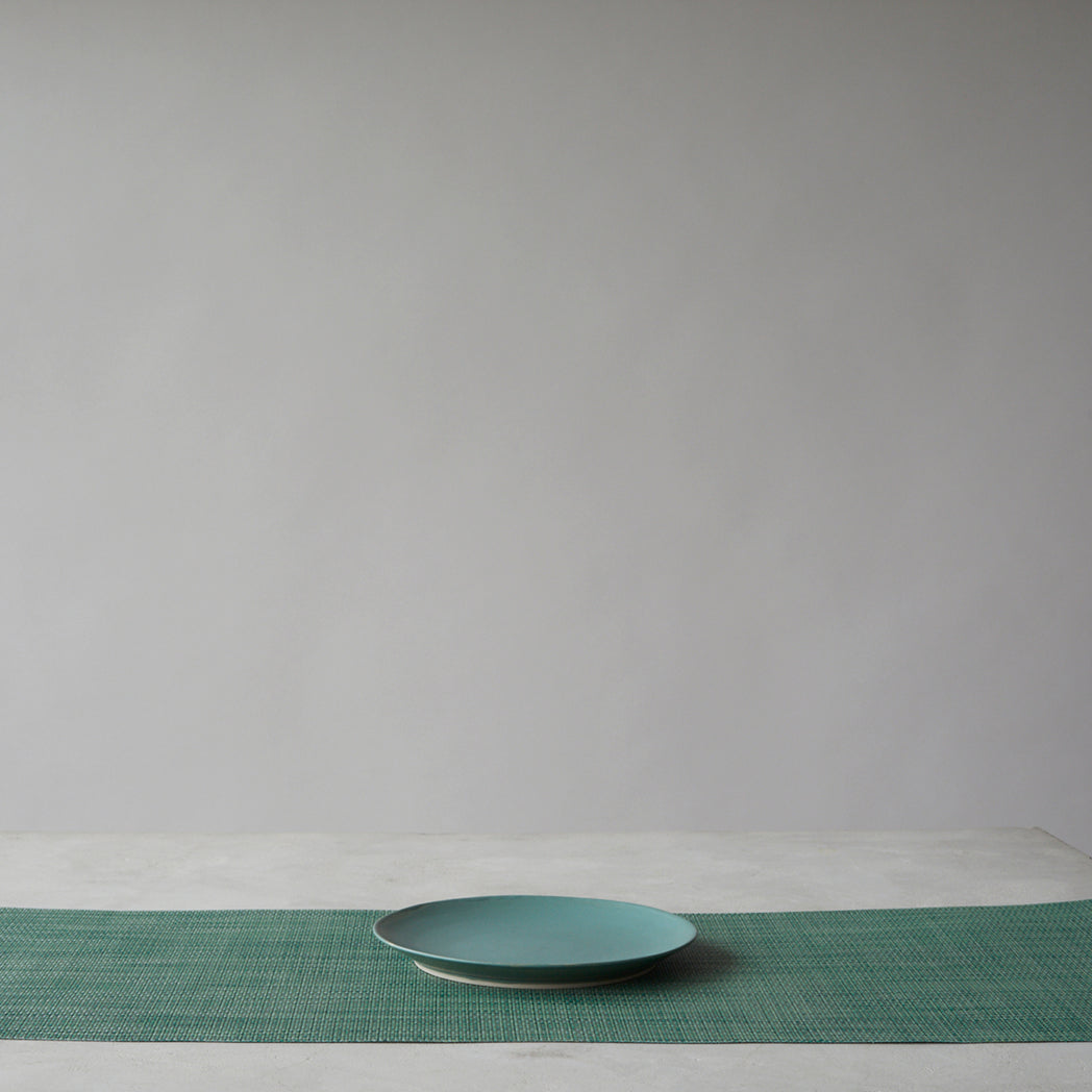 Chilewich Basketweave floor mat in ivy, showcasing woven terrastrand yarn texture and modern design aesthetic.
