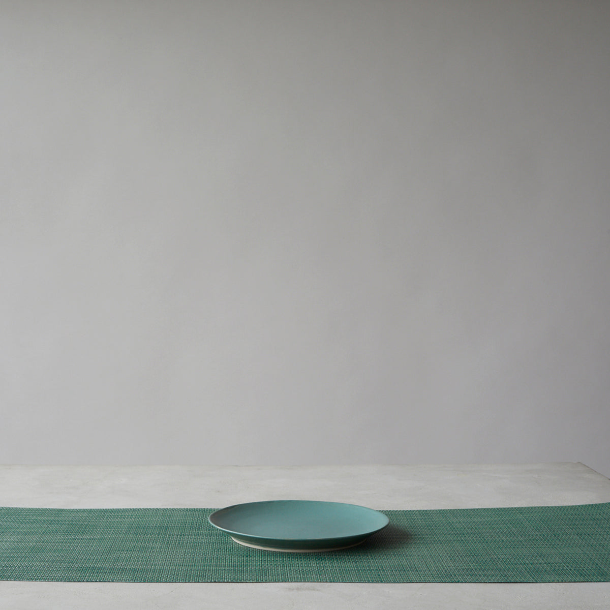 Chilewich Basketweave floor mat in ivy, showcasing woven terrastrand yarn texture and modern design aesthetic.
